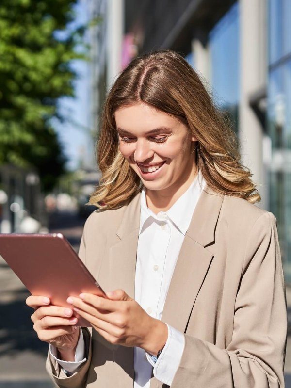 portrait-of-happy-businesswoman-smiling-holding-digital-tablet-on-street-near-office-building-rd87gagzqnk2mdvcdaiqhnsckfwczsk5fk8gmaux4w